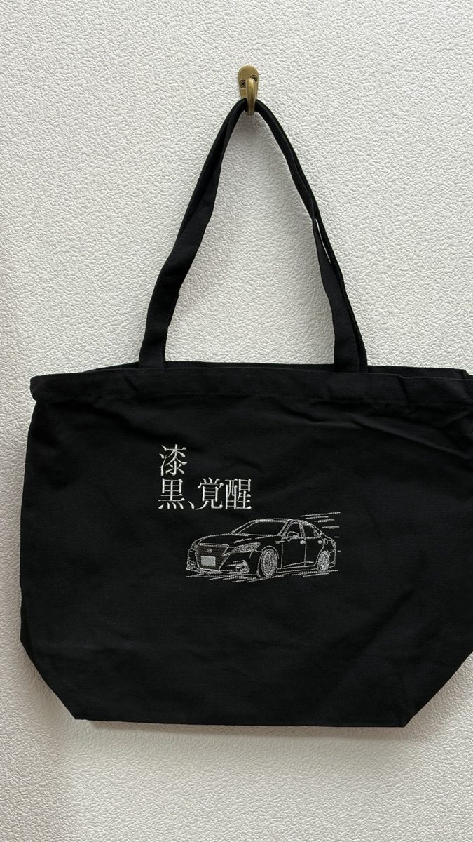 黒いトートバッグに白糸で刺繍したクラウンと『漆黒、覚醒』の文字